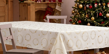 Nappe rectangulaire Luxy blanche à cercles et étoiles dorés, mise en scène sur une table de Noël
